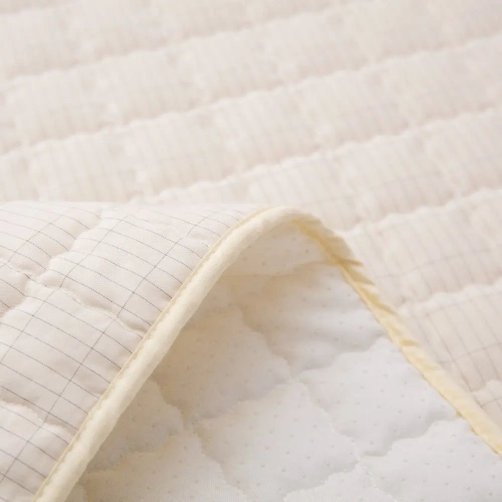 Close-up of a quilted mattress pad with a soft texture.