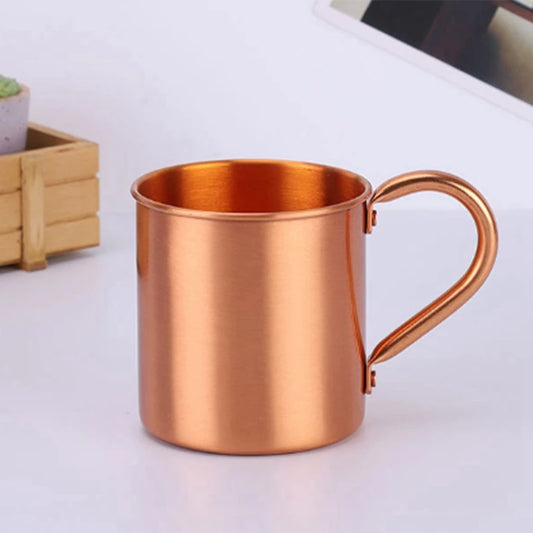 Copper mug on a white surface with a blurred background