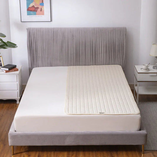 Bed with a mattress pad in a bedroom setting